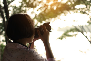 Asian girl shooting picture in the park traveling on holiday.