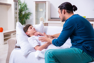 Obraz premium Young father caring for sick son