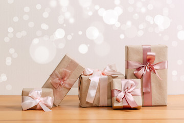 set of beautiful different gift boxes made by handmade with pink bows on a wooden table with a light background. flat lay