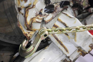 Chain with hook on the background of crumpled crushed metal, car body repair