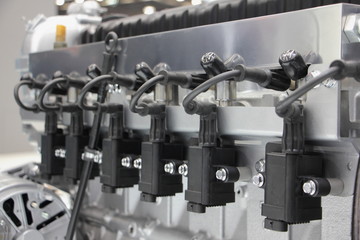Six ignition coils on gasoline truck engine motor, close up view in perspective
