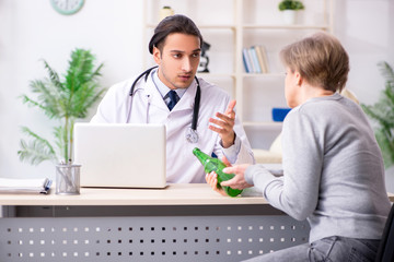 Obraz premium Female alcoholic visiting young male doctor
