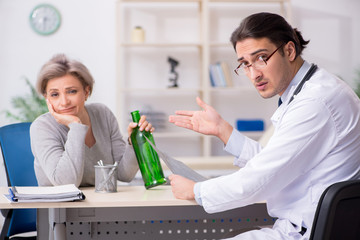 Female alcoholic visiting young male doctor