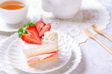 Close up - Homemade cake, Strawberry Shortcake on white plate with tea and decorated with strawberries giving the feeling of the morning atmosphere.