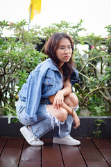 Nerdy Asian woman in white t-shirt and ripped jeans