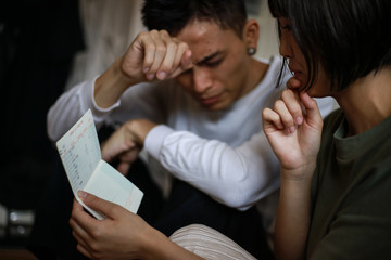 通帳を見ながら悩む夫婦