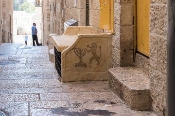 Bench with a picture of a Menorah and a lion in a quiet street of the Old City in Jerusalem, Israel