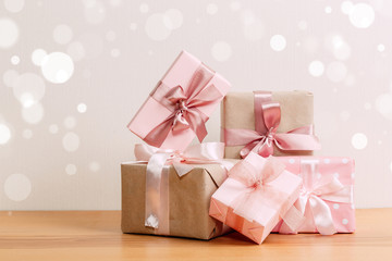 set of beautiful different gift boxes made by handmade with pink bows on a wooden table with a light background. flat lay
