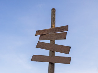 Four Wooden blanks sign stick in the bamboo have blue sky in the background.have space for put text.The symbol blank has brown colour.