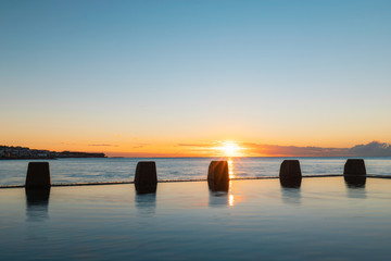 Sunrise view at Coogee rock pool with still water.