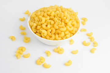 Dried corneti rigati Italian pasta in a round bowl ready to be cooked, isolated on white table, with view from above 