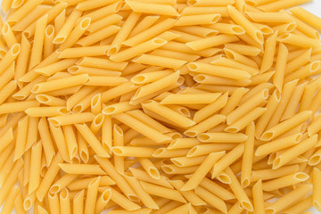 Large group of penne Italian pasta ready to be cooked, displayed as background with top view