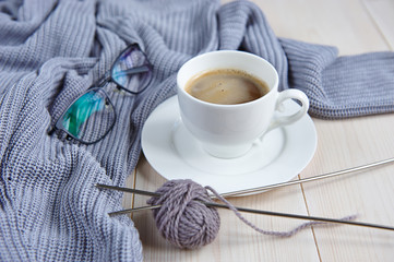 composition of gray knitted sweaters, glasses, a cup of coffee