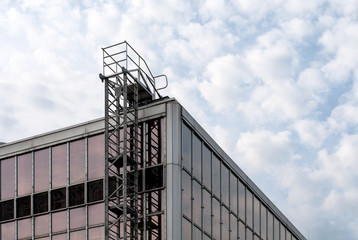 permanently installed metal ladder at glass facade