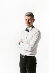 Portrait of young smiling handsome showman in white shirt with bowtie, studio shot isolated on white background. Businessman