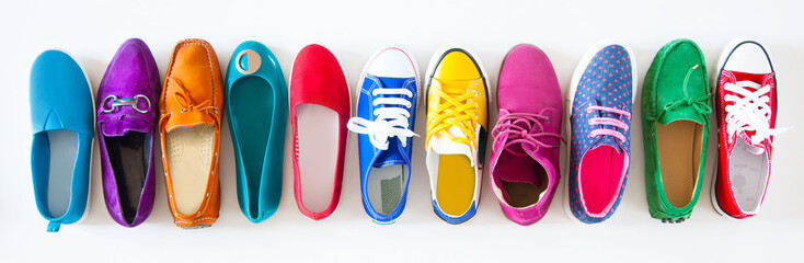 A lot of colored youth women's shoes without heels. Sneakers, slippers, ballet shoes. White background. - obrazy, fototapety, plakaty