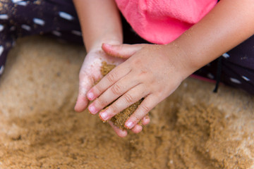 Lifestyle portrait mom son and daughter  playing with sand, Funny Asian family in a public  playground.