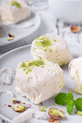 Cotton candy with pistachio on ceramic plate on white wooden table