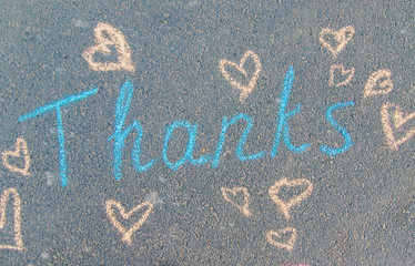 The inscription thank you in chalk on the pavement. Selective focus.