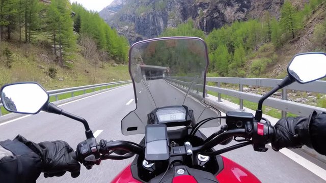 Motorcyclist on Motorbike Rides on a Beautiful Landscape Mountain Road near Swiss Alps