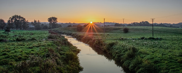 A sunrise over Trentham in Staffordshire. Pictured running through the landscape is a small stream...