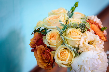 Wedding bouquet made of variety of roses on a blue wall background