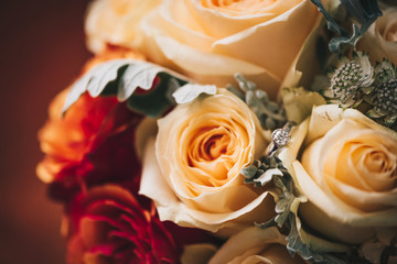 Wedding bouquet mae of roses  and an engagement ring on it