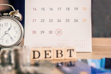 debt collection and tax season concept with deadline calendar remind note,coins,credit card on table