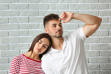 Fashionable young couple against brick wall