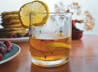 tea with lemon in a transparent mug and a white background