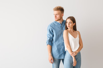 Young couple in stylish casual clothes on light background