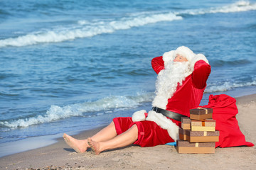 Obraz premium Santa Claus with gifts at sea resort