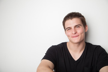 smiling happy young man, trying to hide teeth, dimples