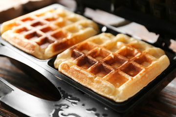 Preparing of tasty waffles in modern maker, closeup