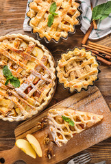 Tasty apple pies on wooden table