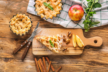 Tasty apple pies on wooden table