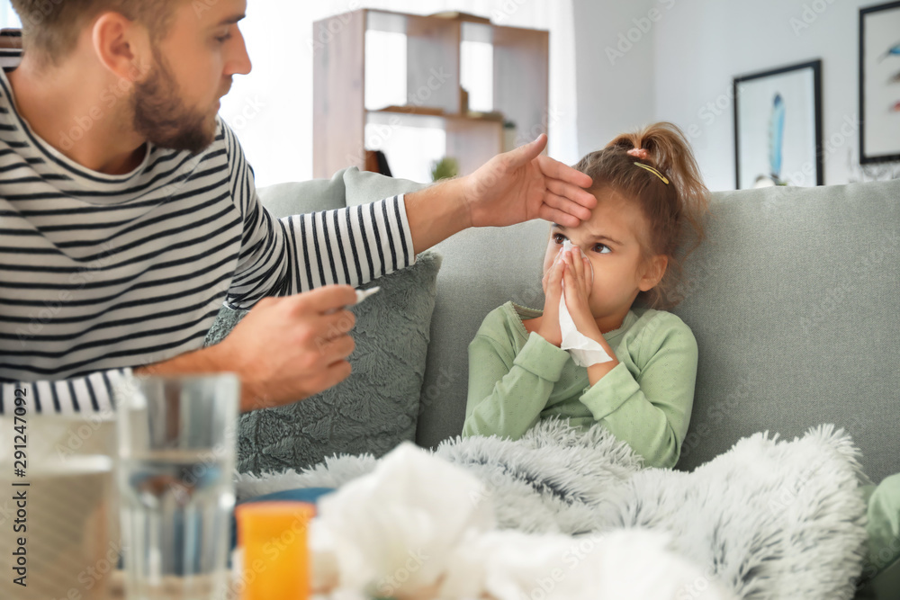 Wall mural Father taking care of his daughter ill with flu at home