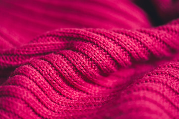 Waved knitted textile with parallel pattern braids closeup. Winter season. Selective focus.