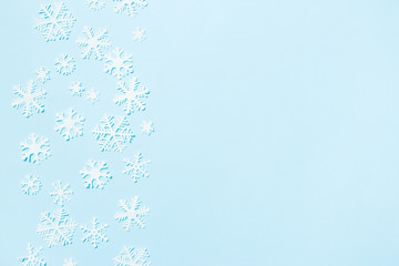 Creative arrangement of christmas decoration snowflakes on blue background. Holiday concept. Flat lay, top view.