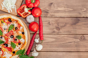 Pizza Margherita or Margarita with Mozzarella cheese, tomato, olive. Italian pizza on wooden background