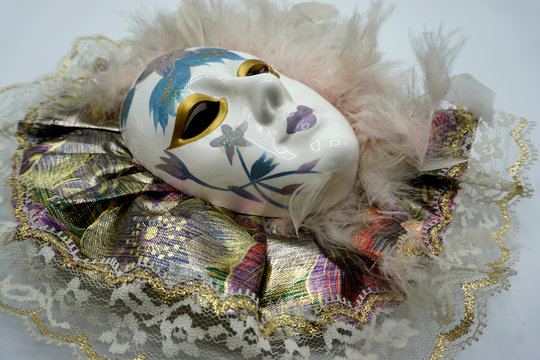 Vintage female porcelain venetian mask with delicate feathers and painted decorations. - Powered by Adobe