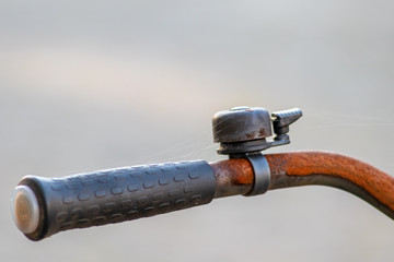 Obraz premium Rostige schwarze Fahrradklingel an altem rostigen Fahrradlenker mit schwarzem Griff und mit unscharfem Hintergrund sorgt für Sicherheit im Straßenverkehr