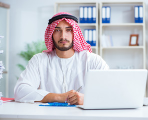 Arab businessman working in the office doing paperwork with a pi