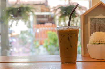 Closeup ices coffee on wooden top desk with nature lighting background