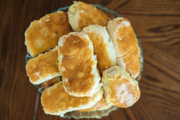 Hot cakes stuffed creeping in a bowl on a wooden table.