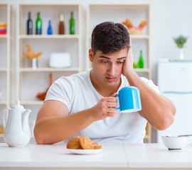 Man falling asleep during his breakfast after overtime work