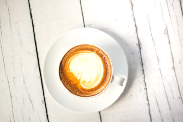Top view a cup of latte art coffee on white wooden