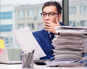Workaholic businessman overworked with too much work in office