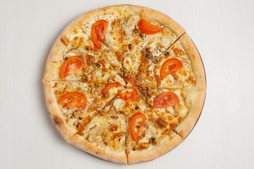 Italian pizza with chicken, walnuts and tomatoes, with white sauce