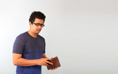 A close-up portrait of a shocked, surprised speechless man asia, holding an empty wallet on white background.